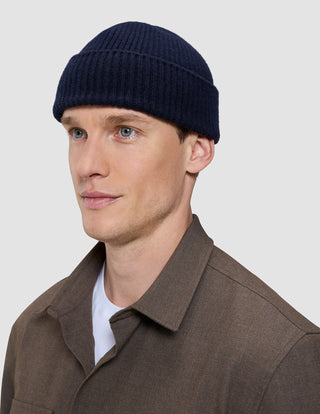 A man wearing a navy blue rib knit Wool Beanie Navy.