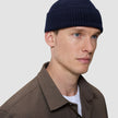 A person wearing a navy blue rib knit Wool Beanie Navy.