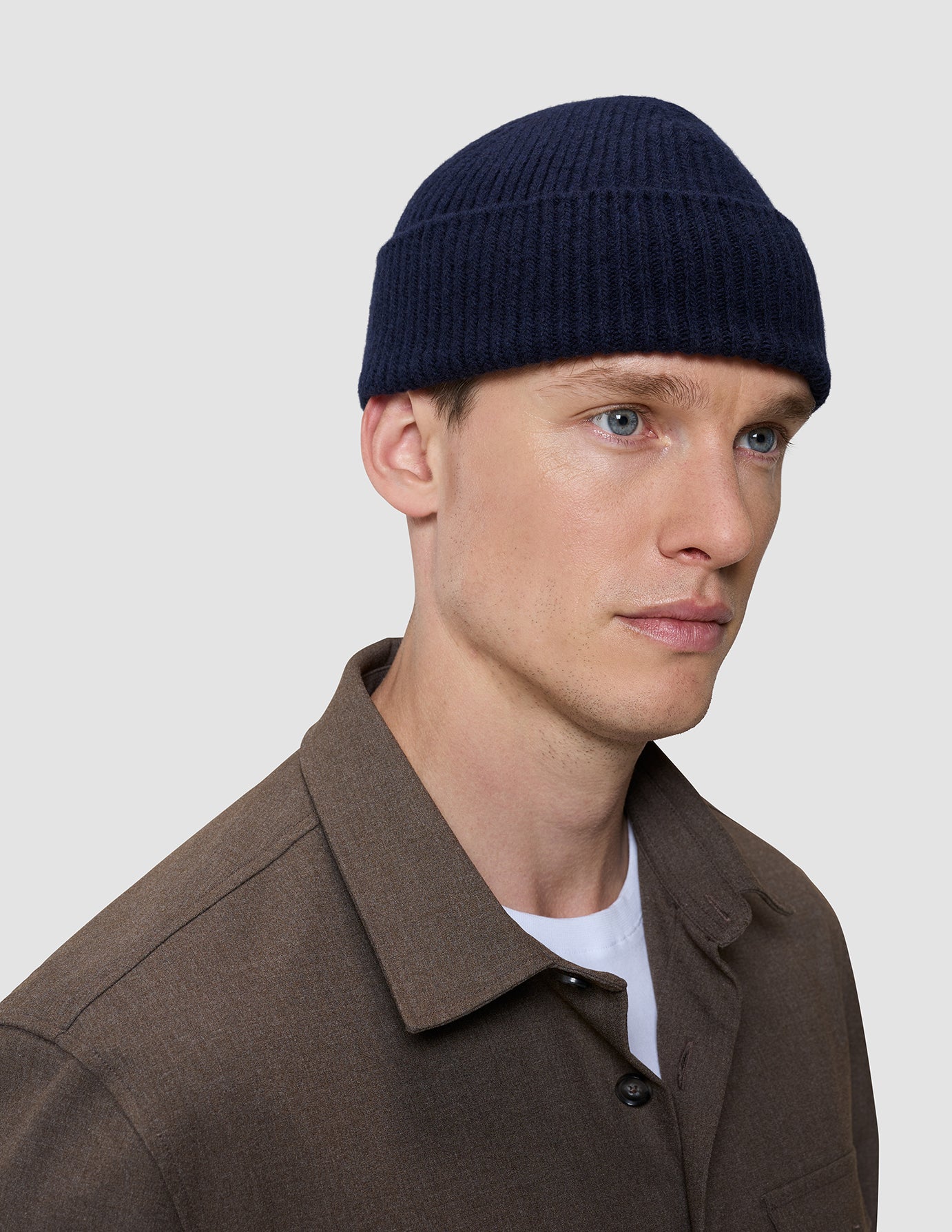 A person wearing a navy blue rib knit Wool Beanie Navy.