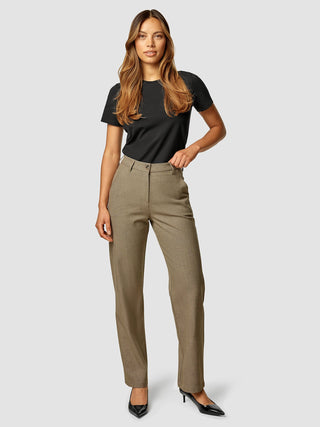 A woman wearing a black t-shirt and Essential Pants Straight Latte with black heels.