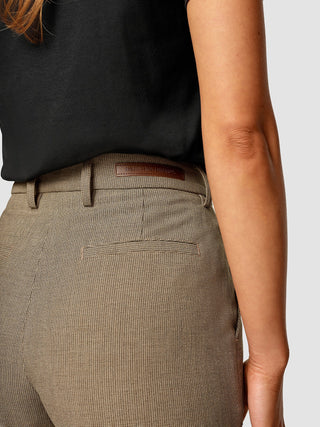 A back view of a woman wearing Essential Pants Straight Latte with a branded label on the waistband.