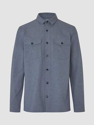 The Essential Overshirt Storm Blue Melange is a versatile long-sleeved button-up shirt featuring two chest pockets in a clean Scandinavian design.