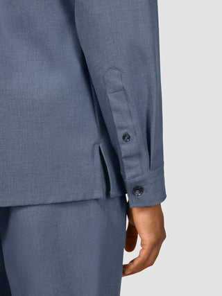 Close-up of the sleeve, cuff, and side hem of an Essential Overshirt Storm Blue Melange, worn with matching trousers to highlight its Scandinavian design.