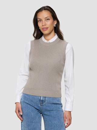 A woman wearing a Women’s Fine Knit Rib Vest Dark Sand over a white collared shirt and blue jeans.