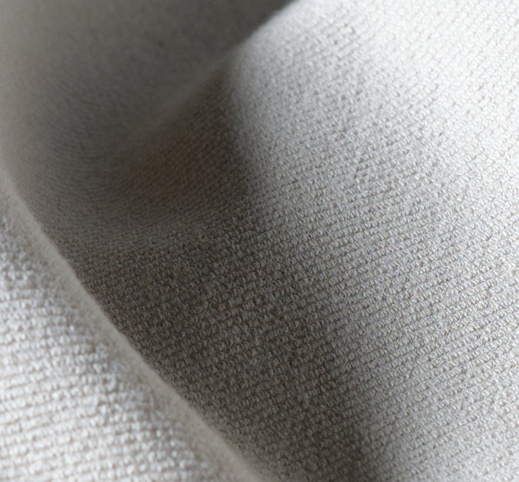 Close-up of beige fabric with a textured weave.