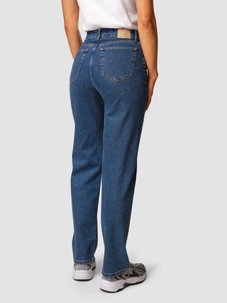 A person viewed from behind wearing Jeans Straight Fit Medium Blue and sneakers.