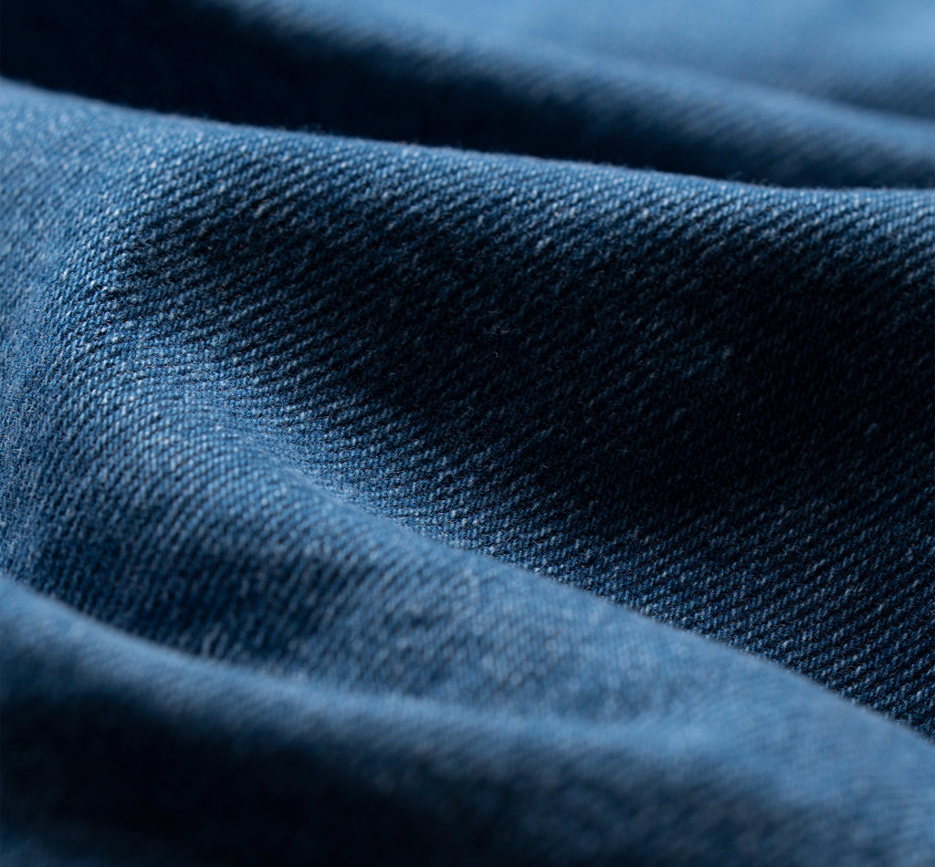 Close-up of folds in blue denim fabric.