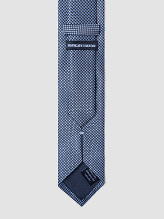 The back of a Tie Structure Shadow Black featuring a Shaping New Tomorrow brand label and a tag indicating it is made in Italy from 100% recycled polyester.