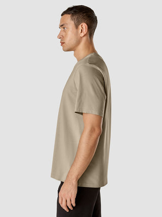 A side profile view of a man wearing a Supima T-shirt Box Fit Globe Sahara.