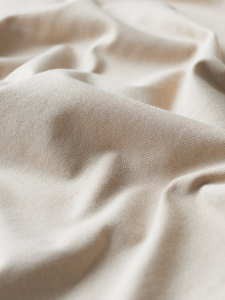 Close-up of Supima T-shirt Box Fit Globe Sahara fabric folded into soft, deep drapes with a 360° stretch.