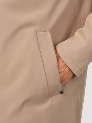 A person’s hand resting inside the side pocket of a Waterproof Trench Coat Sand Grain.