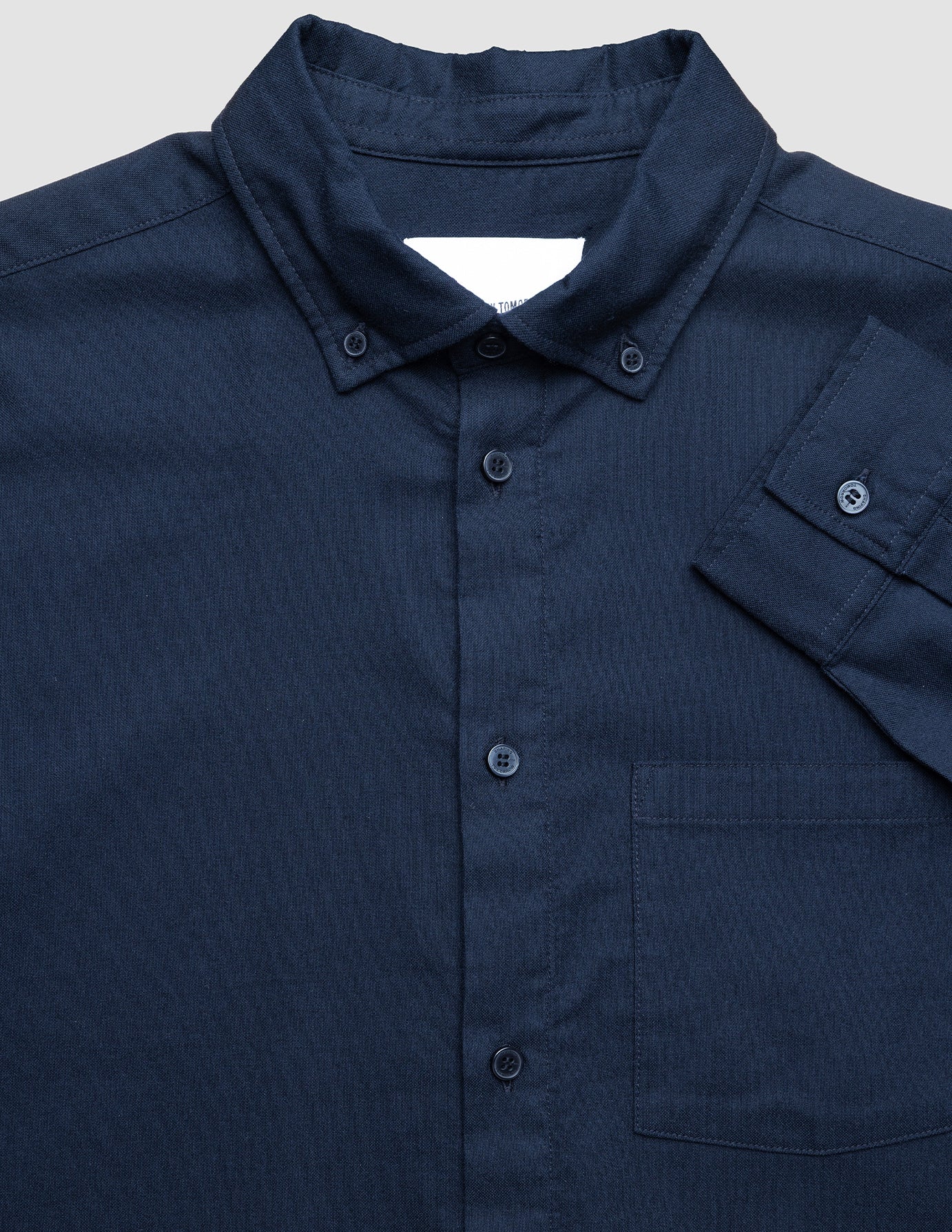 Navy blue shirt with a collar and pocket on a light gray background