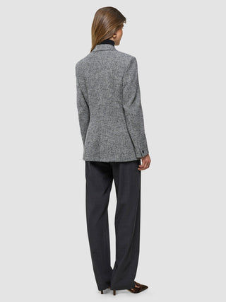 A woman seen from behind wearing a Women Ashryn Blazer Domino Herringbone and dark trousers.