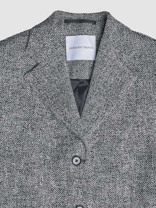 Close-up of a Women Ashryn Blazer Domino Herringbone with a Shaping New Tomorrow label inside the collar.