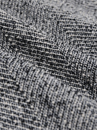 A close-up of the Women Ashryn Blazer Domino Herringbone featuring a black and white chevron pattern with a textured, Scandinavian-inspired bouclé finish.