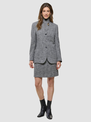 A woman wearing a grey tweed button-up jacket and a Women Ashryn Short Skirt Domino Herringbone.