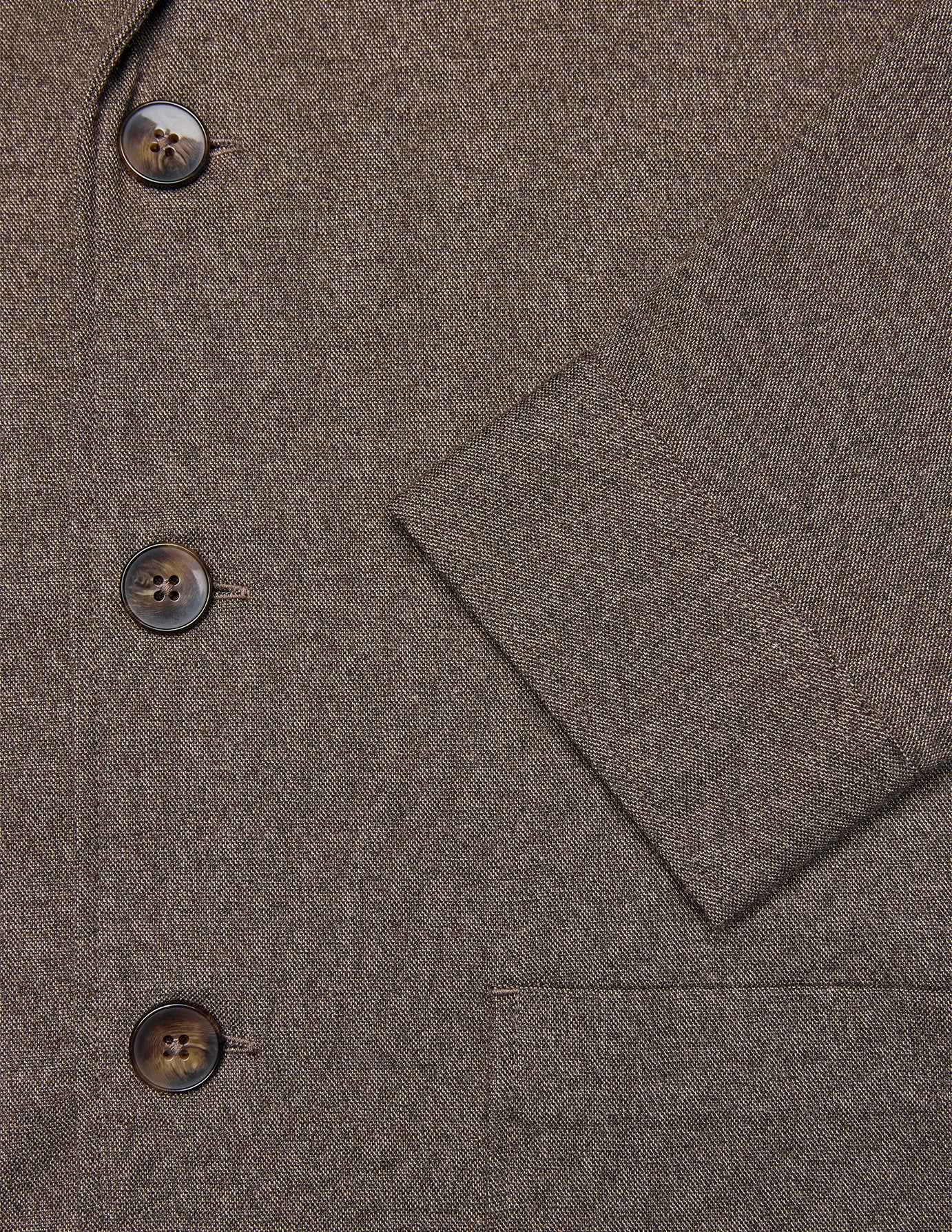 Close-up of the Atelier Overshirt Dark Beige, a heavyweight twill overshirt in dark beige with three brown buttons and a cuffed sleeve in a minimalist Scandinavian design.