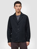A man wearing an Atelier Overshirt in dark navy, featuring a heavyweight textured fabric, a notched collar, and two front patch pockets.