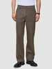 A person wearing dark beige Atelier Pants Relaxed in heavyweight broken twill and black leather dress shoes.