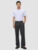A man in a white t-shirt and Atelier Pants Relaxed Dark Grey made from heavyweight broken twill, finished with dark leather loafers.