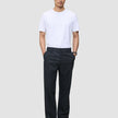 A person wearing a white t-shirt and Atelier Pants Relaxed Dark Navy with their hands in their pockets.