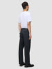 A man seen from behind wearing a white t-shirt and Atelier Pants Relaxed Dark Navy in heavyweight broken twill, paired with black shoes.