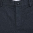 Close-up of Atelier Pants Relaxed Dark Navy, featuring a relaxed fit, button closure, and an interior brand label reading Shaping New Tomorrow.