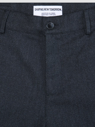 Close-up of Atelier Pants Relaxed Dark Navy, featuring a relaxed fit, button closure, and an interior brand label reading Shaping New Tomorrow.