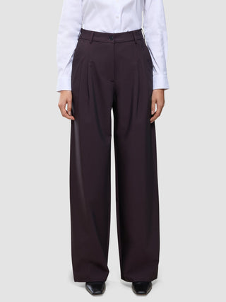 Women’s Avira Pants Wide Burgundy Berry featuring a high-waisted, wide-fit silhouette paired with a white button-down shirt.
