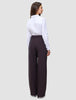 A person viewed from the back wearing a white button-down shirt tucked into Women’s Avira Pants Wide Burgundy Berry.