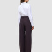 A person viewed from the back wearing a white button-down shirt tucked into Women’s Avira Pants Wide Burgundy Berry.