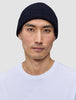 A man wearing a Wool Beanie Navy, a navy blue merino wool rib knit beanie.