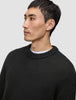A man wearing a black Chunky Soft Wool Knit Crewneck over a white shirt, reflecting a clean Scandinavian design.