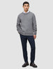 A man wearing a Chunky Soft Wool Knit Crewneck Glacier Grey sweater over a white collared shirt, dark trousers, and dark loafers.