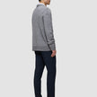 A man in profile wears a glacier grey Chunky Soft Wool Knit Crewneck over a collared shirt, paired with navy trousers and dark loafers.