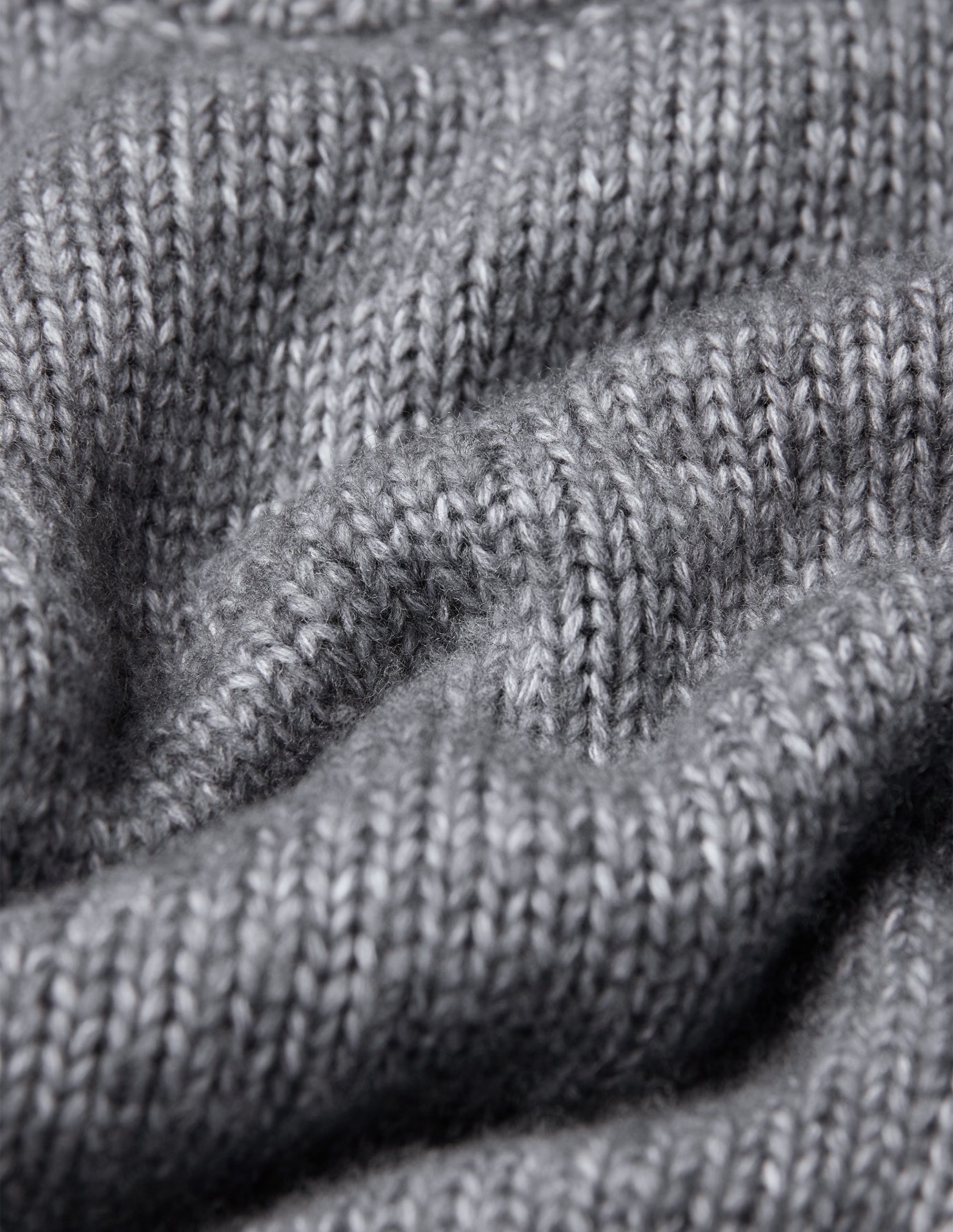 Close-up of a grey, chunky knit Chunky Soft Wool Knit Crewneck Glacier Grey sweater with visible yarn texture.