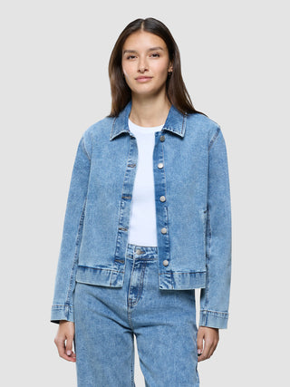 A woman wearing a white t-shirt and a Women’s Classic Denim Jacket Snow Blue Wash with matching jeans.