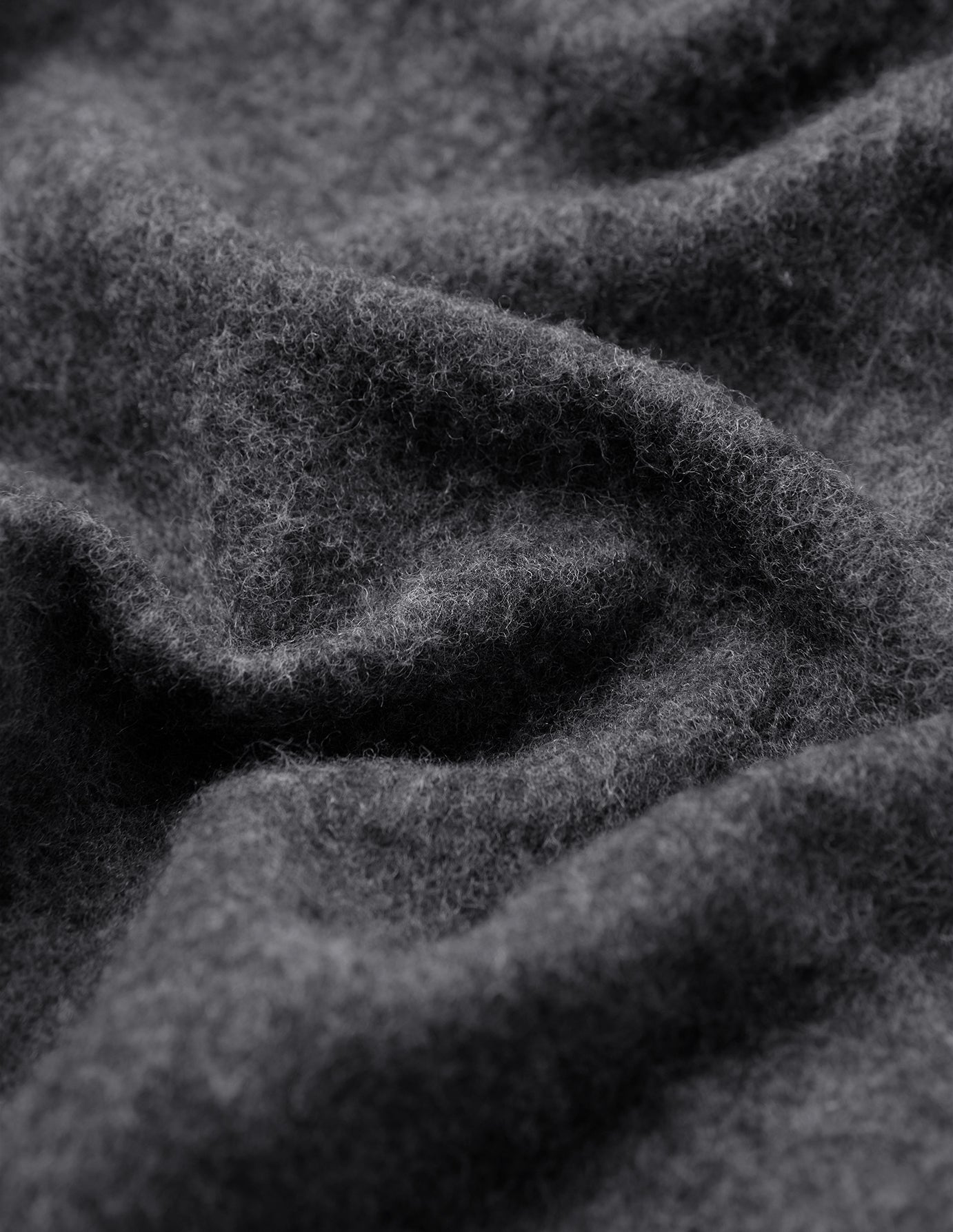 Close-up of the Double Layer Wool Overshirt Regular Dark Grey, showing the thick, dark grey felted wool blend fabric with folds.