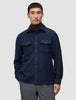 A man wears a Double Layer Wool Overshirt Regular Dark Navy over a brown turtleneck, showcasing a clean Scandinavian design with two chest pockets.