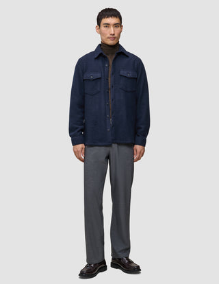 A man wearing a Double Layer Wool Overshirt Regular Dark Navy over a brown turtleneck sweater and grey trousers.