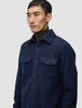 A man wearing a dark navy Double Layer Wool Overshirt Regular Dark Navy with two chest pockets over a dark brown turtleneck.