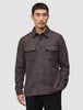 A man wearing a Double Layer Wool Overshirt in saddle brown, featuring a button-up front and two chest pockets.