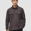A man wearing a Double Layer Wool Overshirt in saddle brown, featuring a button-up front and two chest pockets.