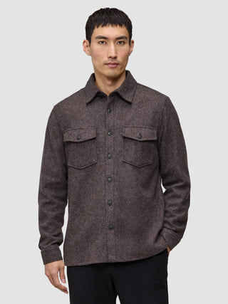 A man wearing a Double Layer Wool Overshirt in saddle brown, featuring a button-up front and two chest pockets.