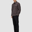 A person wearing a Double Layer Wool Overshirt Saddle Brown with two chest pockets, black trousers, and black loafers.