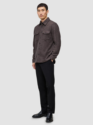 A person wearing a Double Layer Wool Overshirt Saddle Brown with two chest pockets, black trousers, and black loafers.