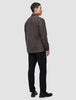 A person seen from behind wearing a Double Layer Wool Overshirt Saddle Brown, black trousers, and black loafers.
