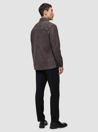 A person seen from behind wearing a Double Layer Wool Overshirt Saddle Brown, black trousers, and black loafers.