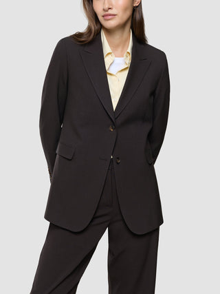 A person wearing a Women Ease Blazer Mocha Melange over a light yellow button-up shirt.