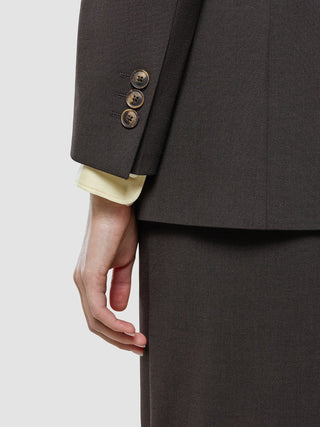 Close-up of a dark brown Women Ease Blazer Mocha Melange sleeve with three buttons and a cream-colored shirt cuff visible underneath.